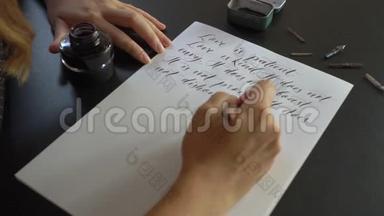 一位年轻女子用刻字技巧在纸上书写书法的特写镜头。 她写结婚誓言爱